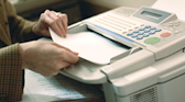 employee retrieving documents passing through the fax machine